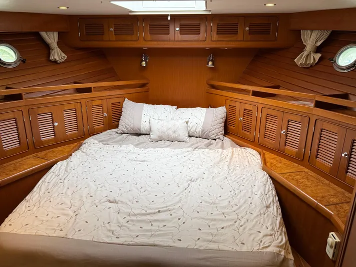 Marco Polo Yacht Photos Pics Luxurious 2004 Selene Pilothouse cabin with cozy bedding and elegant wood paneling.