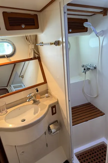 Marco Polo Yacht Photos Pics Compact bathroom in 2004 Selene Pilothouse yacht with shower, sink, and wooden accents.