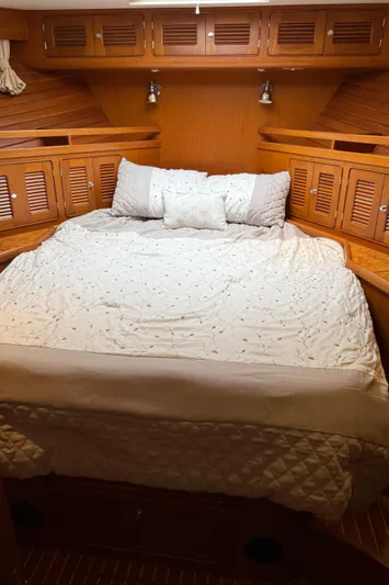 Marco Polo Yacht Photos Pics 2004 Selene Pilothouse cabin with cozy bed and wooden storage cabinets.