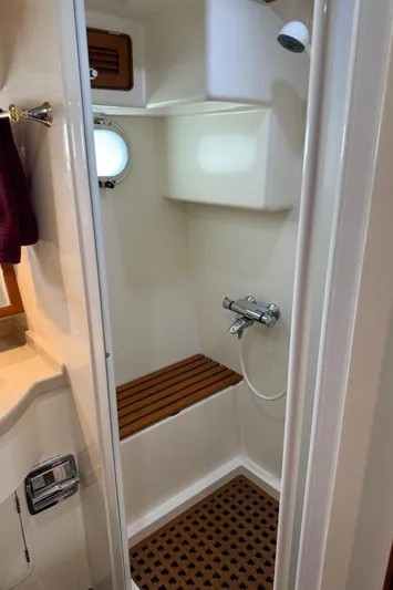Marco Polo Yacht Photos Pics Compact shower area in a 2004 Selene Pilothouse boat, featuring wooden accents and modern fixtures.