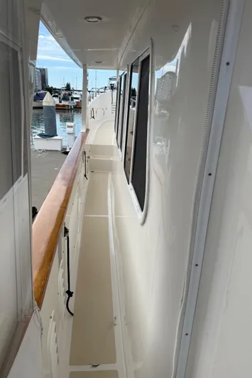 Marco Polo Yacht Photos Pics 2004 Selene Pilothouse yacht deck with wooden railing, docked at marina.