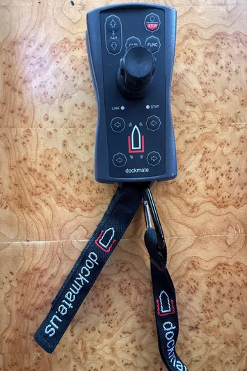 Marco Polo Yacht Photos Pics Dockmate remote control on wooden surface, featuring joystick and lanyard.