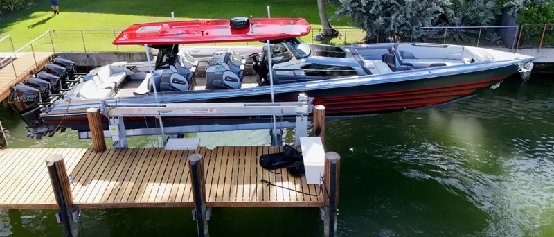  Yacht Photos Pics 2022 Nor-Tech 50 Sport boat with red canopy docked on a lift.