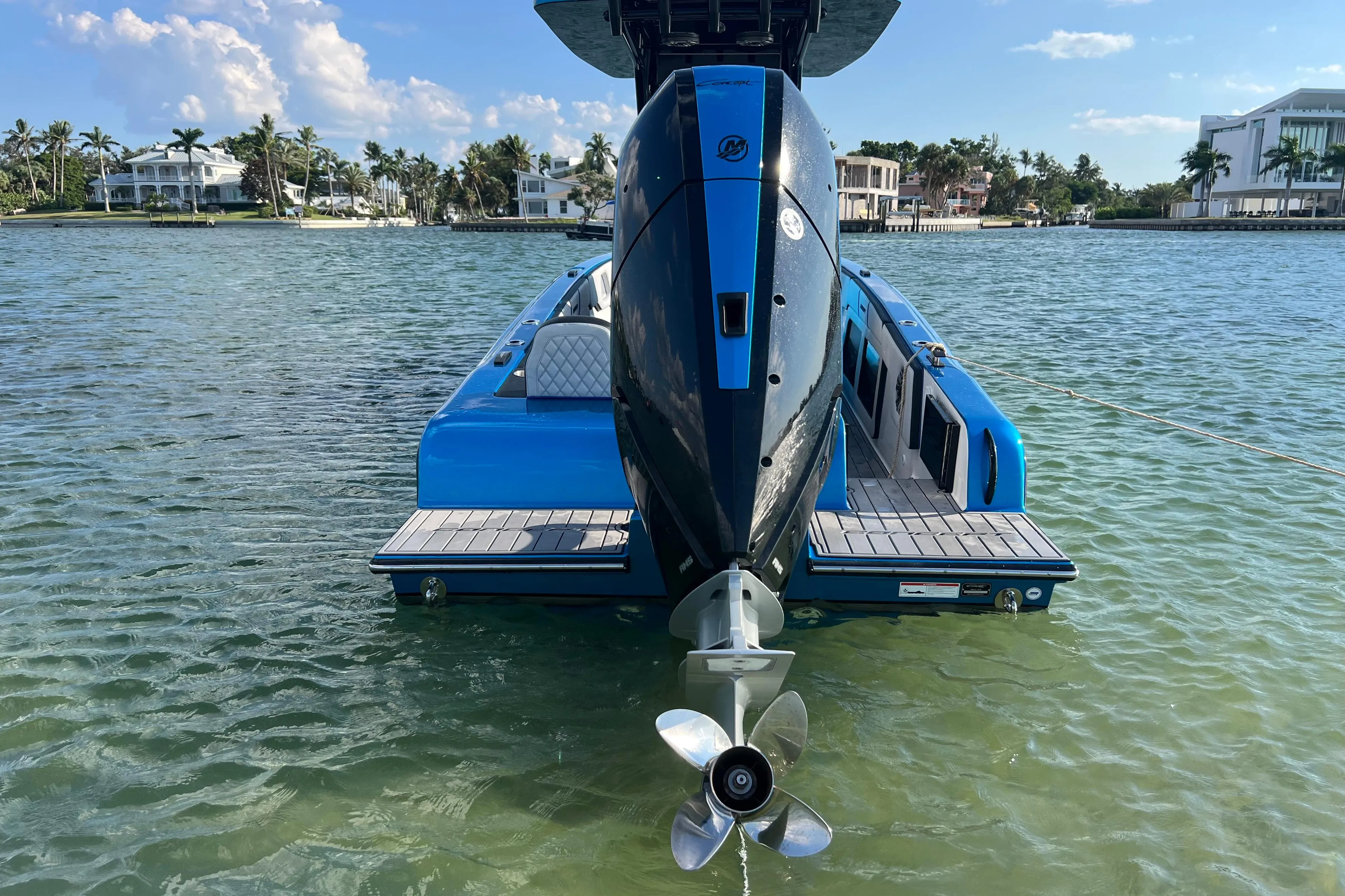 2025 Concept 27' Open Deck boat on clear water, showcasing sleek design and powerful engine.