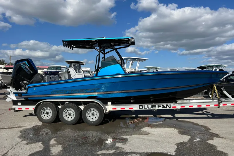  Yacht Photos Pics 2025 Concept 27' Open Deck boat on trailer, vibrant blue, under a cloudy sky.