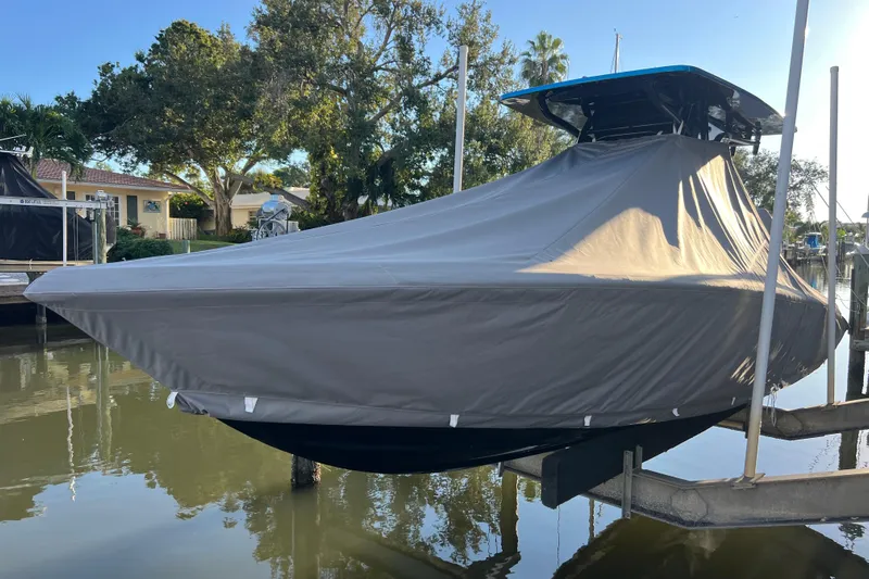  Yacht Photos Pics Covered 2025 Concept 27' Open Deck boat on lift, surrounded by trees and water.