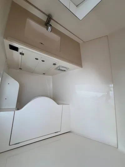 Pursuit 32dc Yacht Photos Pics Interior of 2015 Pursuit 325DC boat, featuring a compact, modern bathroom with sink and storage.