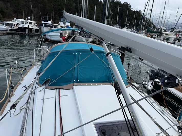 Seaglass Yacht Photos Pics 2019 Jeanneau Sun Odyssey 349 sailboat docked in a marina, featuring a blue canopy.
