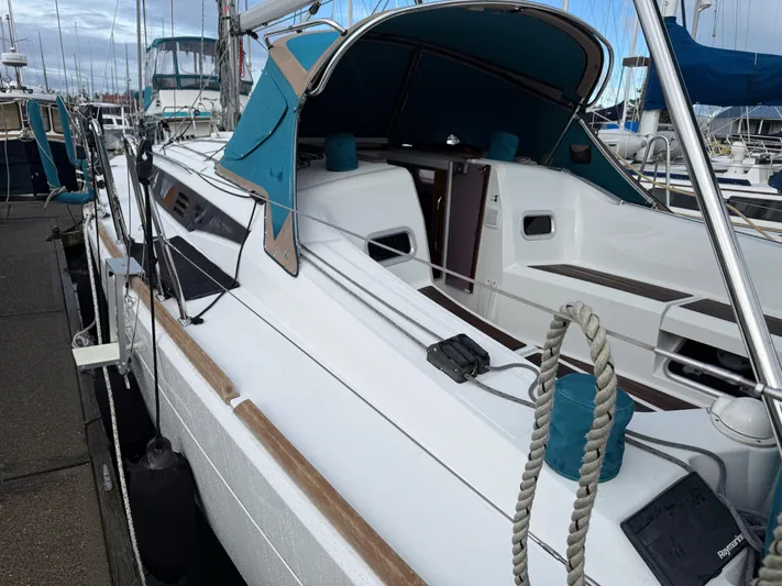 Seaglass Yacht Photos Pics 2019 Jeanneau Sun Odyssey 349 sailboat docked at marina, featuring sleek design and blue canopy.