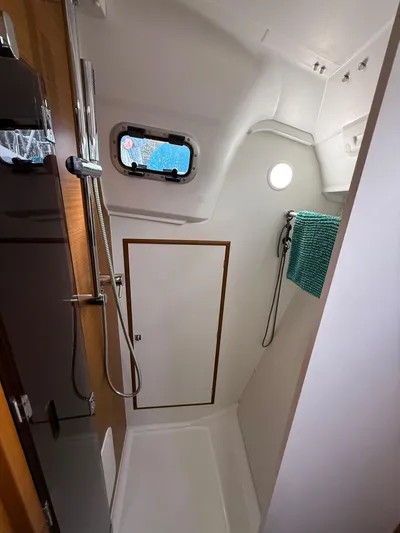 Seaglass Yacht Photos Pics 2019 Jeanneau Sun Odyssey 349 bathroom with shower, porthole, and towel rack.
