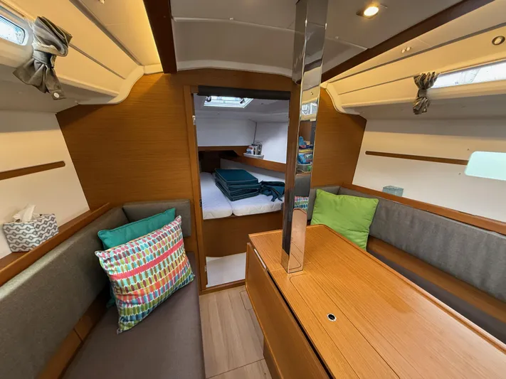Seaglass Yacht Photos Pics Interior of 2019 Jeanneau Sun Odyssey 349 sailboat, featuring cozy seating and a cabin bed.