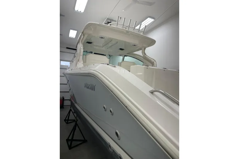  Yacht Photos Pics 2024 Pursuit DC 326 Dual Console boat in a well-lit indoor storage.