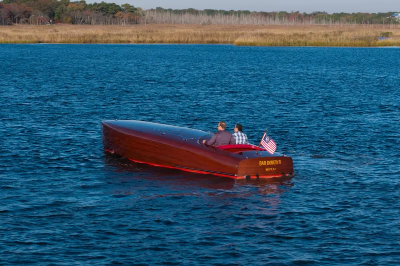  Yacht Photos Pics Custom 1998 30 Gentleman's Racer boat on a serene lake with two passengers.