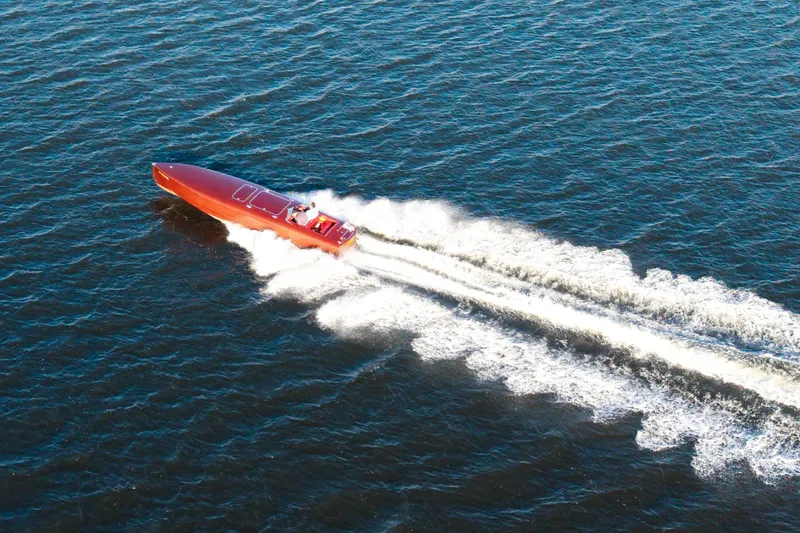  Yacht Photos Pics Custom 30 Gentleman's Racer boat from 1998 speeding on open water, aerial view.