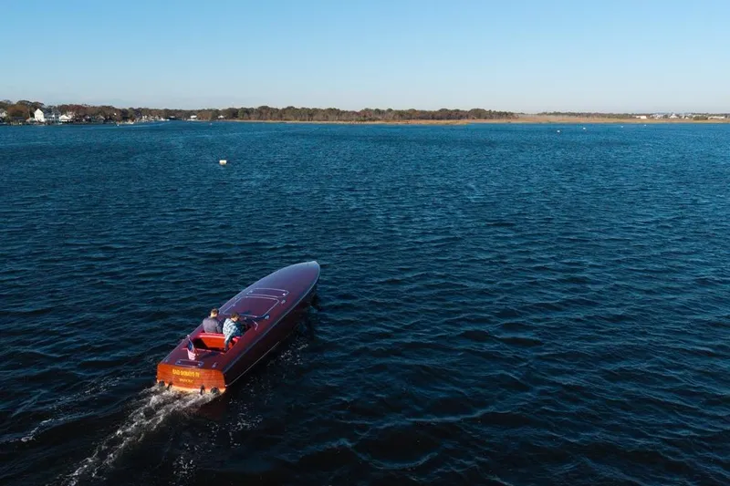  Yacht Photos Pics Custom 1998 30 Gentleman's Racer cruising on a serene lake under clear blue skies.