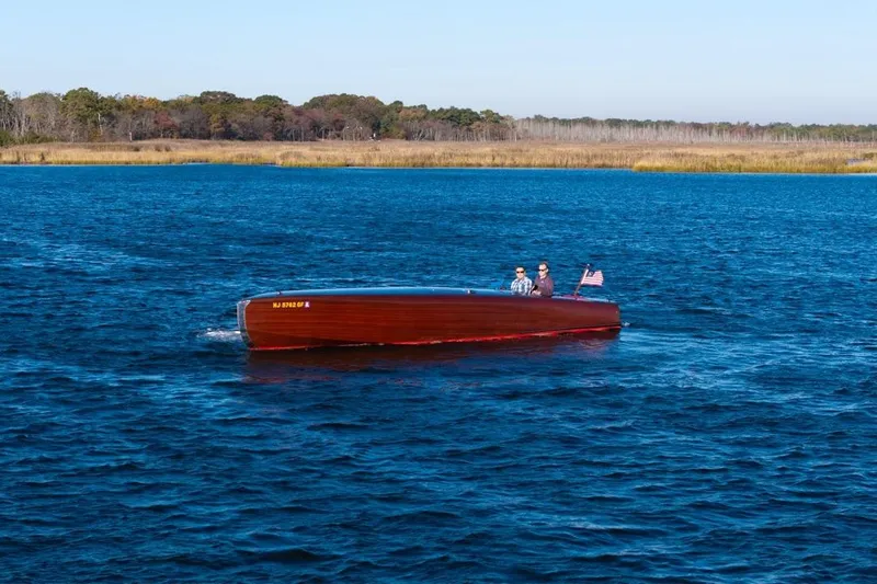  Yacht Photos Pics Custom 30 Gentleman's Racer boat from 1998 cruising on a serene blue lake.