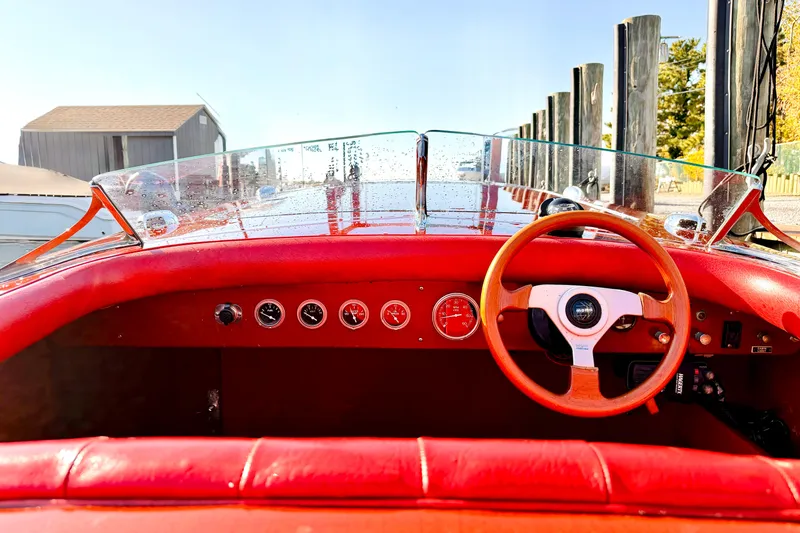  Yacht Photos Pics Interior of a 1998 Custom 30 Gentleman's Racer with red dashboard and wooden steering wheel.