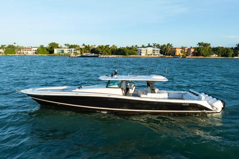  Yacht Photos Pics 2021 HCB 65 Estrella luxury boat cruising on blue waters near a scenic coastline.