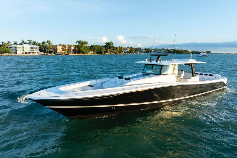  Yacht Photos Pics 2021 HCB 65 Estrella luxury yacht cruising on blue waters near a tropical shoreline.