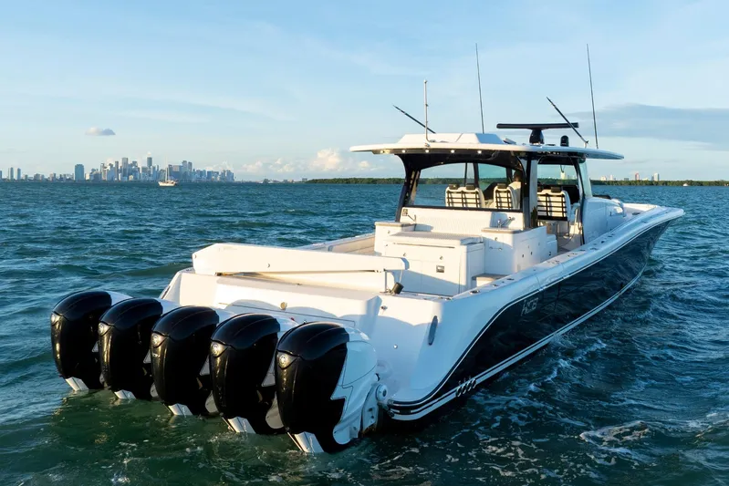  Yacht Photos Pics 2021 HCB 65 Estrella boat cruising on ocean with city skyline in background.