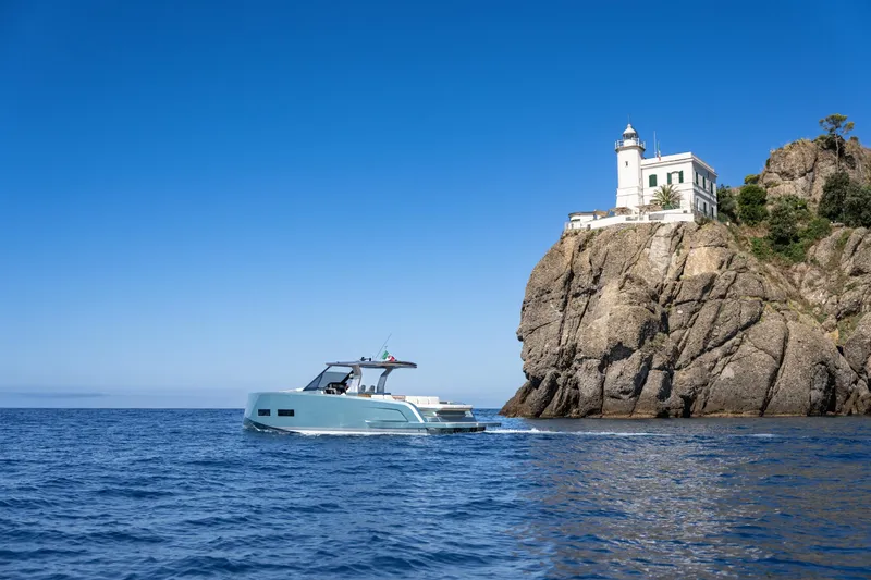 Pardo 43 Yacht Photos Pics 2026 Pardo Yachts 43 cruising near a rocky cliff with a lighthouse.