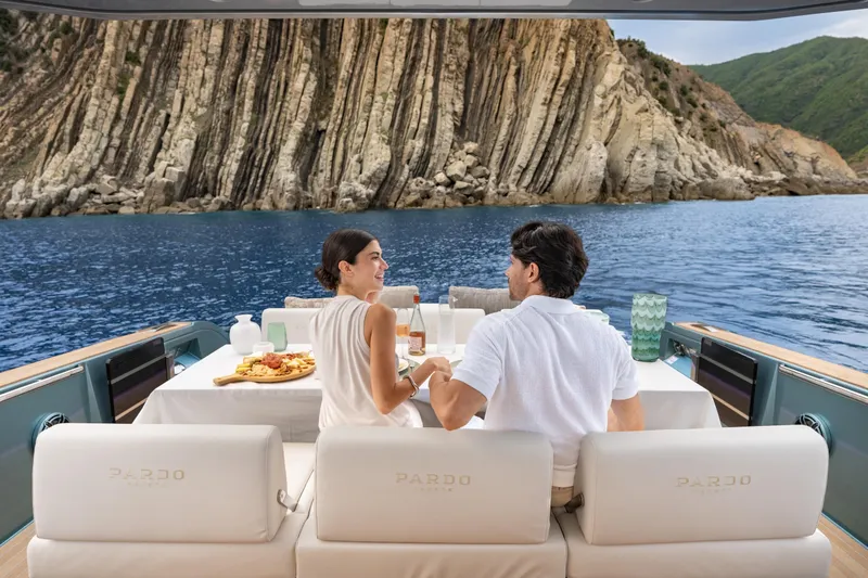 Pardo 43 Yacht Photos Pics Couple enjoying a meal on a 2026 Pardo Yachts 43, with scenic coastal backdrop.