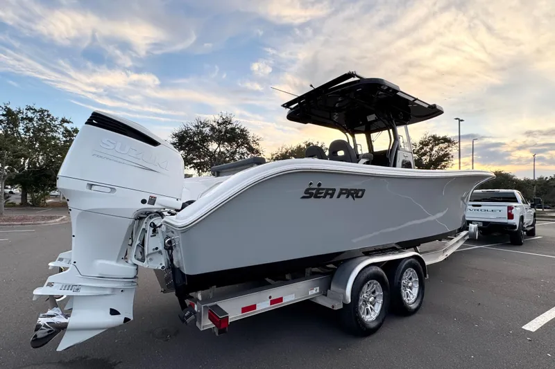  Yacht Photos Pics 2024 Sea Pro 292 DLX boat on trailer with Suzuki engine, parked under a cloudy sky.