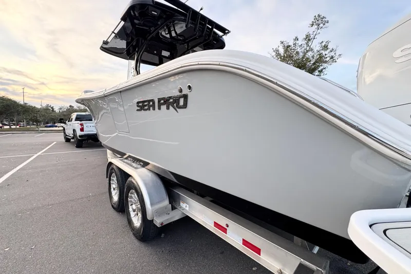  Yacht Photos Pics 2024 Sea Pro 292 DLX boat on trailer, parked in a lot at sunset.