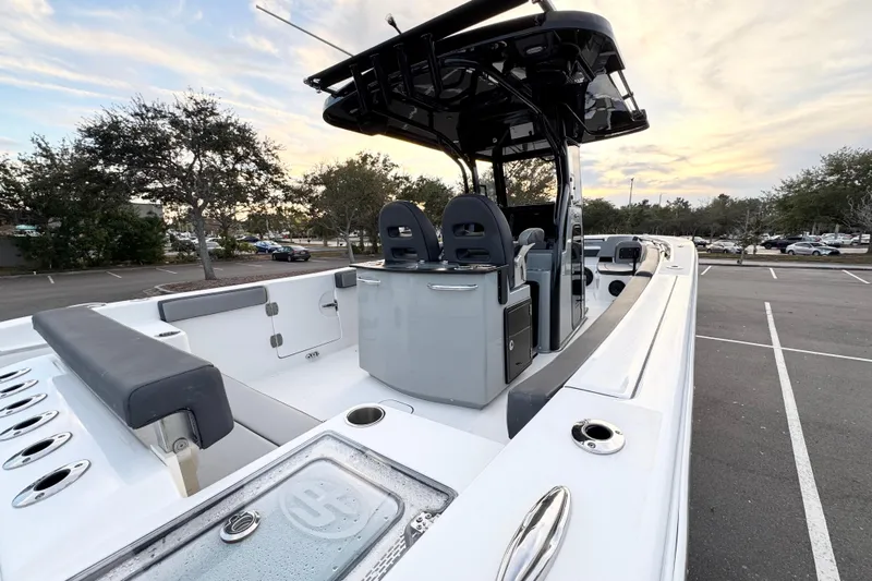  Yacht Photos Pics 2024 Sea Pro 292 DLX boat interior with seating and console, parked outdoors at sunset.