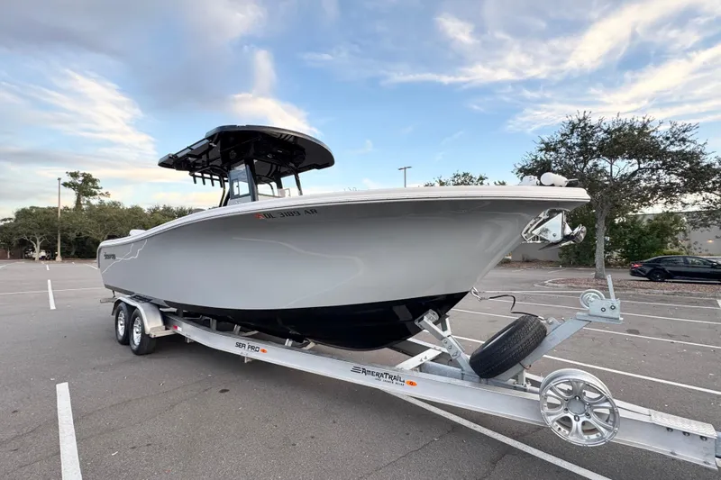  Yacht Photos Pics 2024 Sea Pro 292 DLX boat on trailer in parking lot under blue sky.