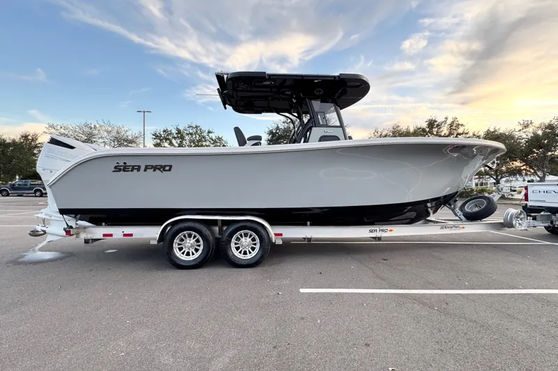  Yacht Photos Pics 2024 Sea Pro 292 DLX boat on trailer, parked in a lot under a cloudy sky.