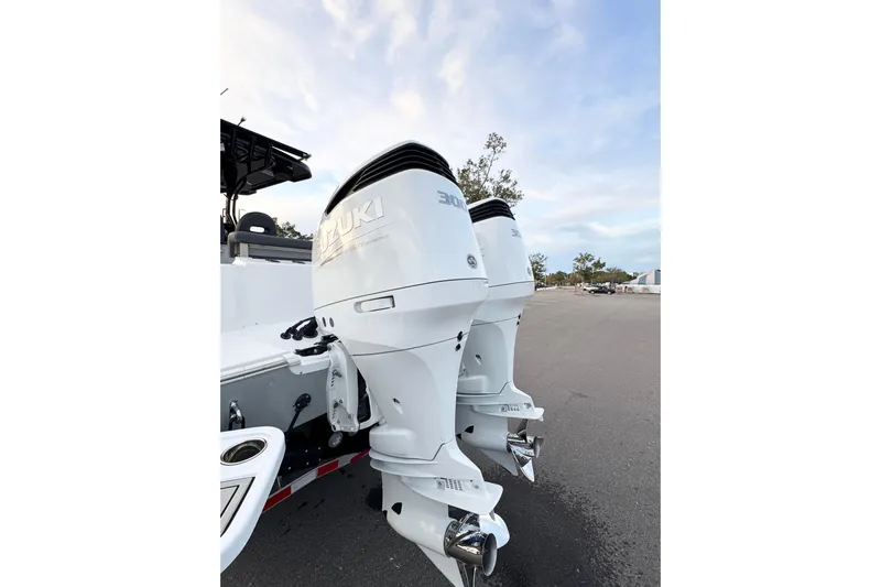 Yacht Photos Pics 2024 Sea Pro 292 DLX boat with dual Suzuki outboard motors in a parking area.