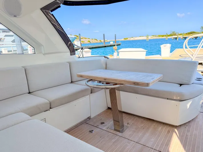  Yacht Photos Pics Interior of 2021 Beneteau Gran Turismo 41 yacht with seating and table, overlooking marina.