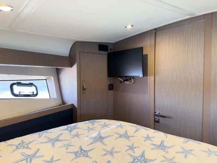  Yacht Photos Pics 2021 Beneteau Gran Turismo 41 cabin with starfish bedding and wall-mounted TV.