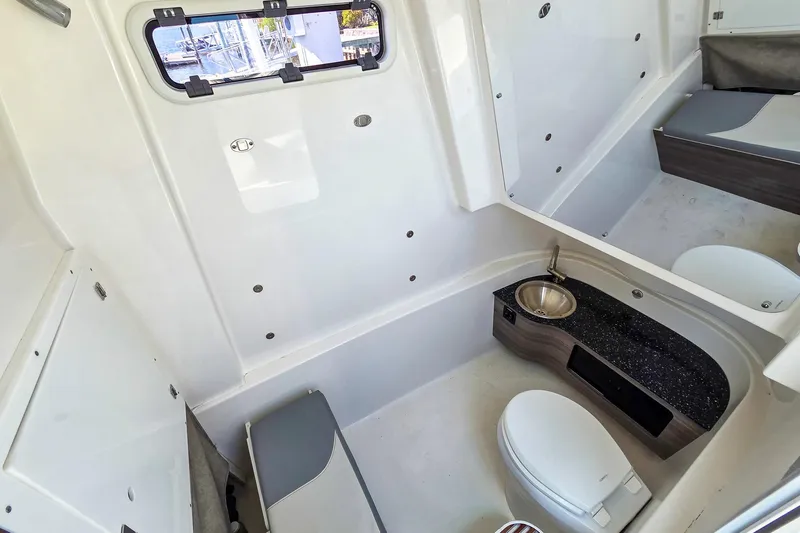  Yacht Photos Pics 2022 Sea Pro 320 DLX Offshore boat interior with sink, toilet, and seating area.