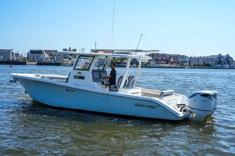  Yacht Photos Pics 2022 Sea Pro 320 DLX Offshore boat cruising on a sunny day near coastal homes.