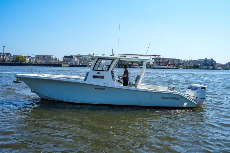 Yacht Photos Pics 2022 Sea Pro 320 DLX Offshore boat cruising on a sunny day near coastal homes.