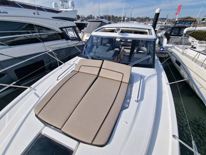 324000084-r40 Yacht Photos Pics 2025 Bavaria R40 yacht with sunbed, docked in marina, showcasing sleek design and luxury features.