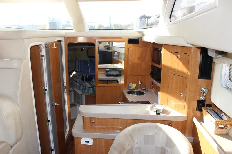  Yacht Photos Pics Interior of 2002 Regal Commodore 3880 yacht with wood cabinetry and compact kitchen area.