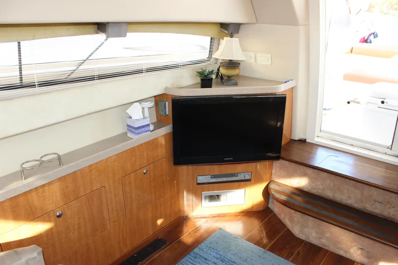 Yacht Photos Pics Interior of 2002 Regal Commodore 3880 yacht with TV, lamp, and wooden cabinetry.