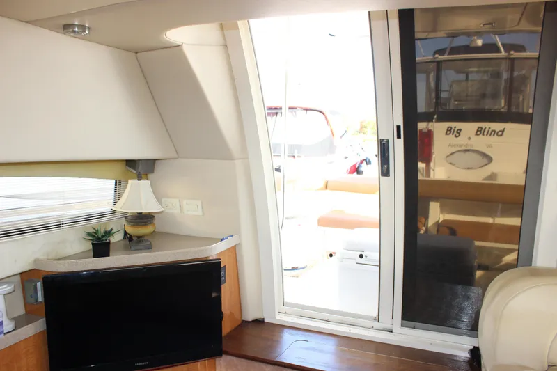  Yacht Photos Pics Interior of 2002 Regal Commodore 3880 yacht with TV, lamp, and sliding glass door.