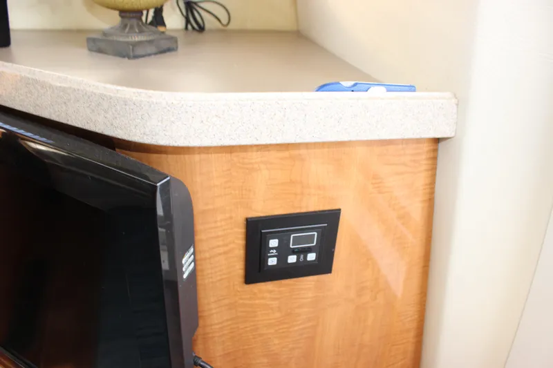  Yacht Photos Pics Control panel and TV in 2002 Regal Commodore 3880 yacht interior.