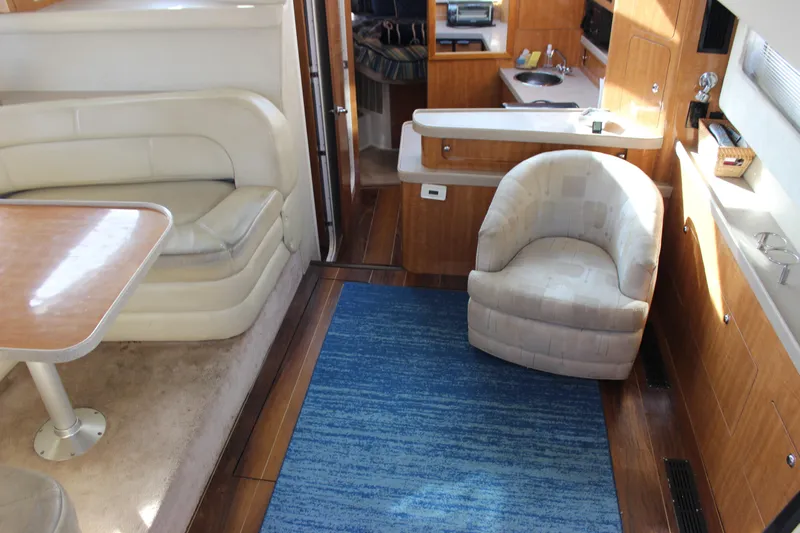 Yacht Photos Pics Interior of 2002 Regal Commodore 3880 yacht with seating, table, and kitchenette.