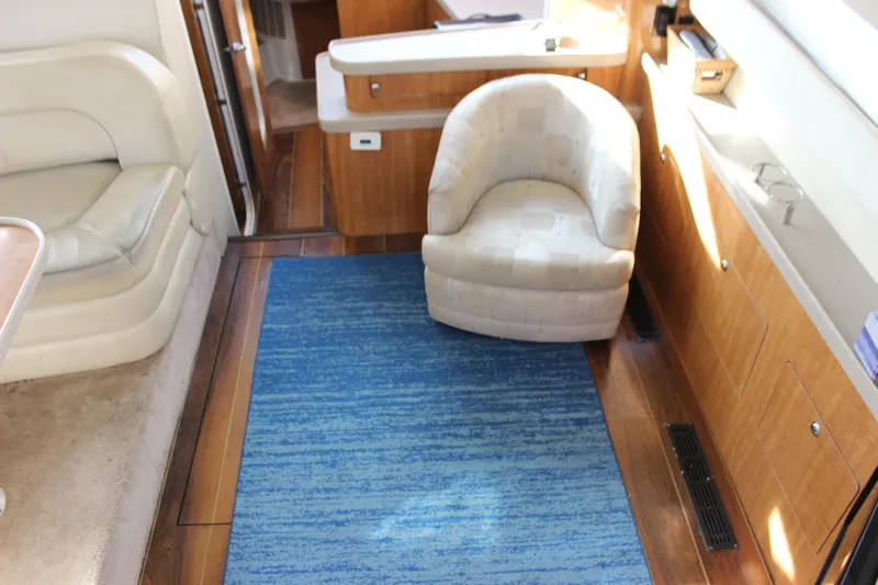  Yacht Photos Pics Interior of 2002 Regal Commodore 3880 yacht with blue rug and beige seating.