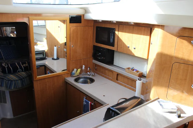  Yacht Photos Pics 2002 Regal Commodore 3880 yacht interior with kitchenette, featuring wood cabinets and modern appliances.