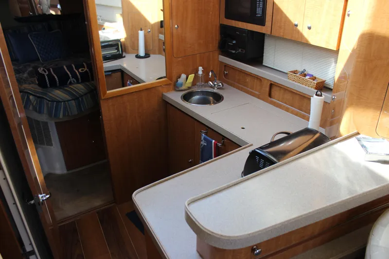  Yacht Photos Pics 2002 Regal Commodore 3880 yacht interior with kitchen and cozy sleeping area.