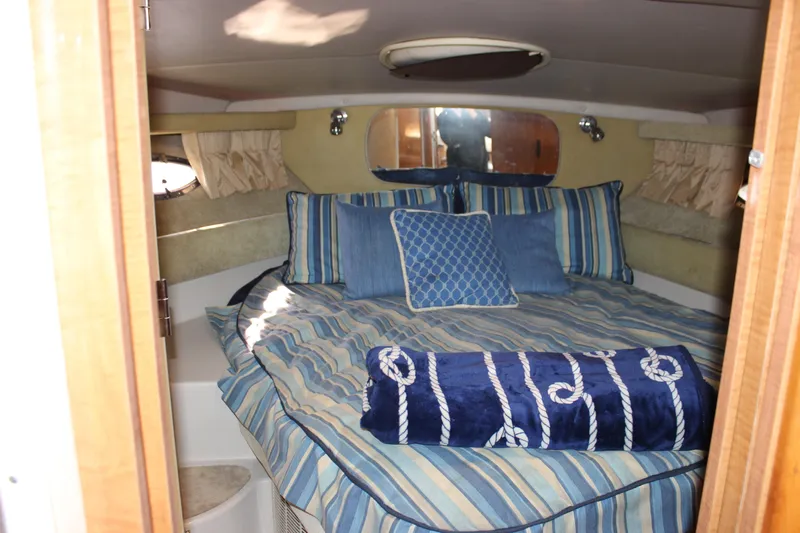  Yacht Photos Pics Cozy cabin interior of 2002 Regal Commodore 3880 with striped bedding and nautical decor.