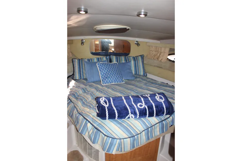 Yacht Photos Pics Interior cabin of 2002 Regal Commodore 3880 with striped bedding and nautical decor.