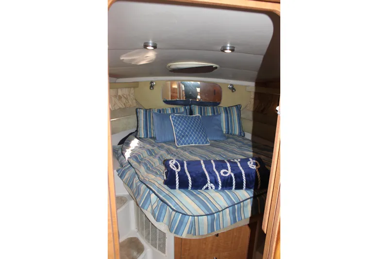  Yacht Photos Pics Cozy cabin interior of 2002 Regal Commodore 3880 with striped bedding and pillows.