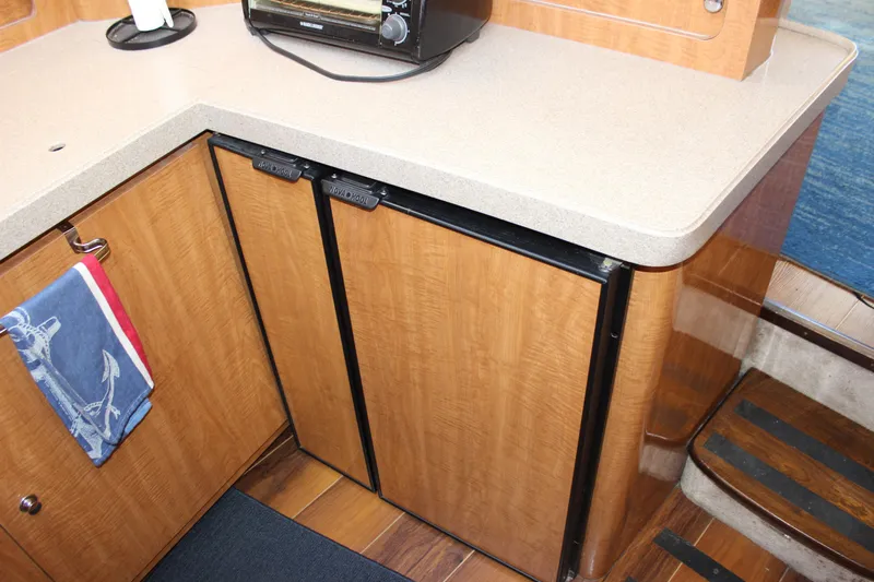  Yacht Photos Pics 2002 Regal Commodore 3880 yacht kitchen with wooden cabinets and compact appliances.